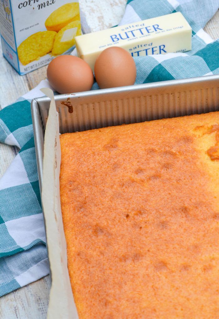 a batch of better cornbread made from a box in a parchment lined metal baking pan