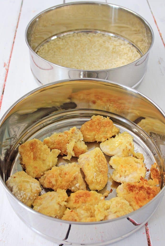 lightly fried chunks of chicken in a silver pot