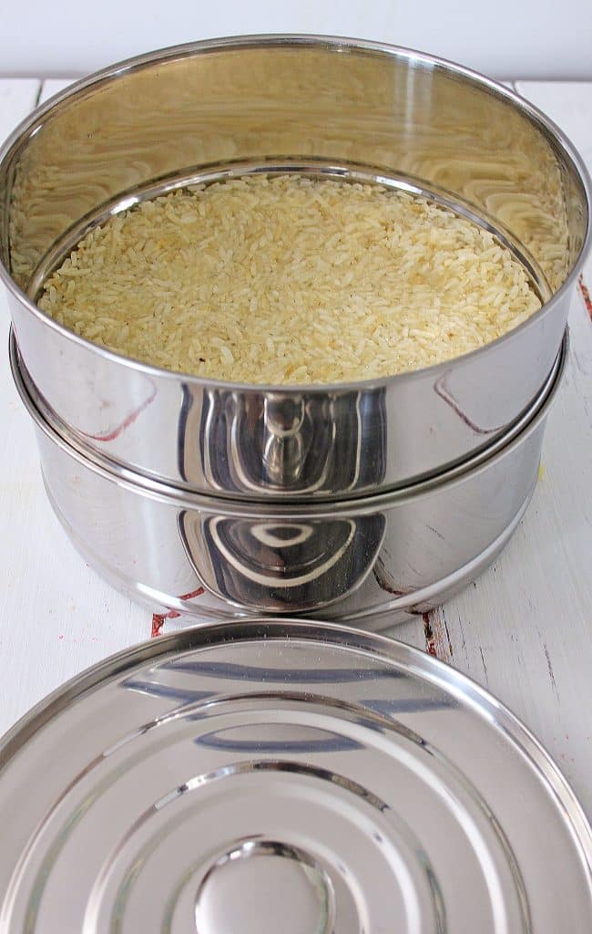 rice ready to be cooked in a small silver pot 