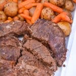 Instant Pot pot roast with carrots & potatoes arranged together on a white serving platter