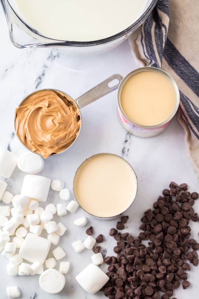 overhead image showing the measured ingredients needed to make a batch of slow cooker peanut butter hot chocolate
