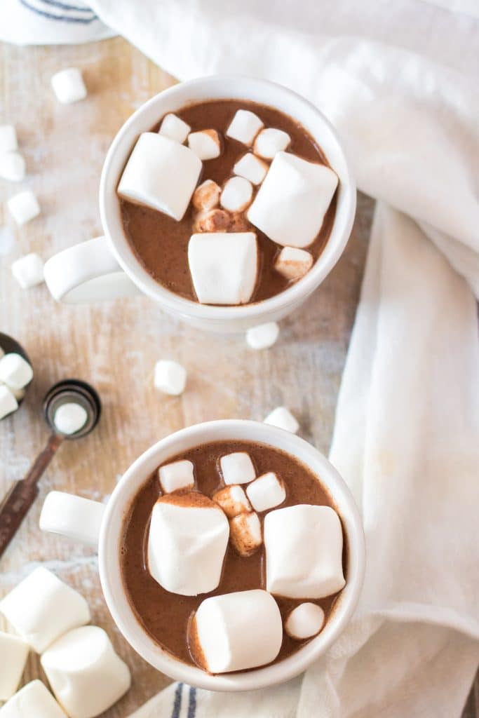 two white mugs filled with peanut butter hot chocolate