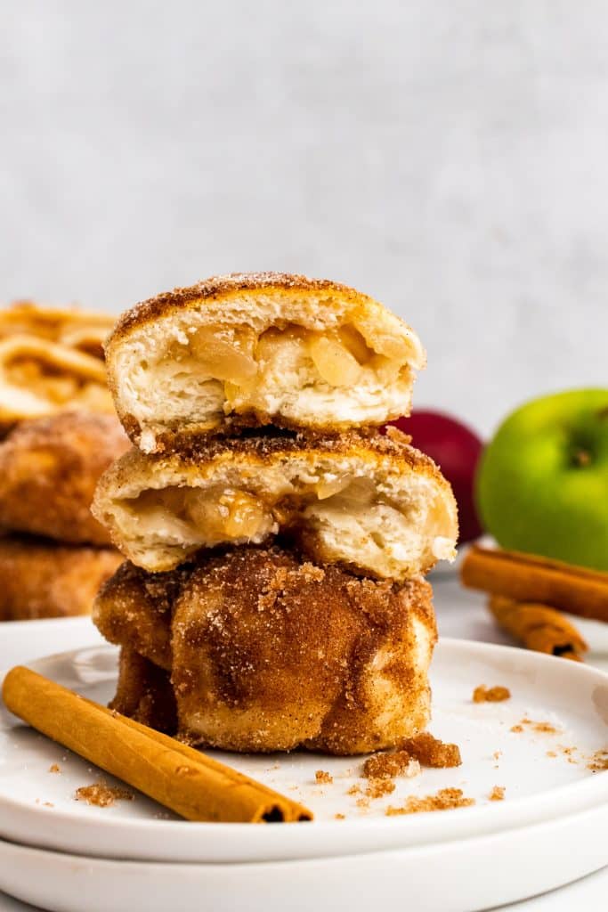 caramel apple pie bombs stacked on a white plate and opened to show the filling