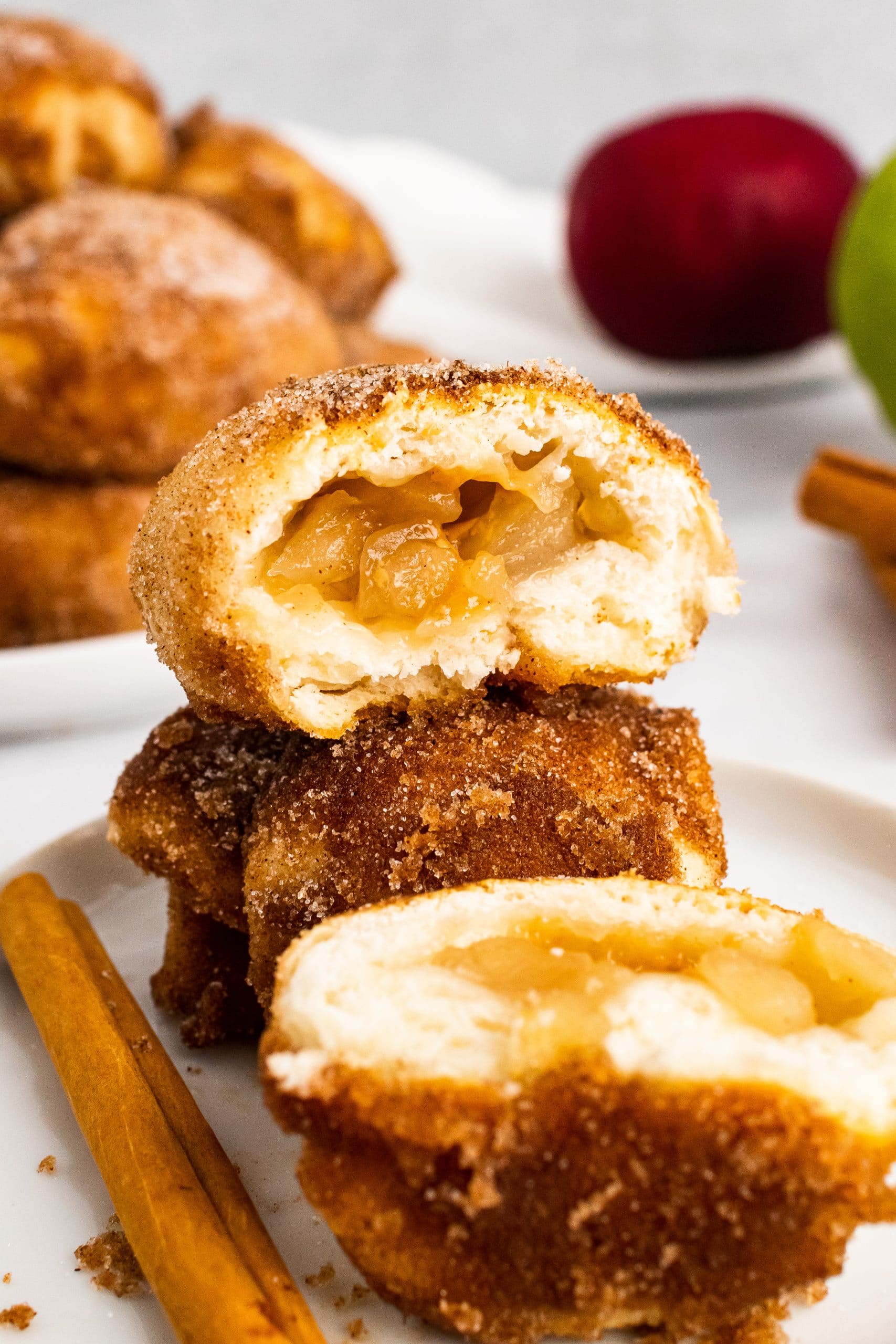 caramel apple pie bombs stacked on a white plate and opened to show the filling