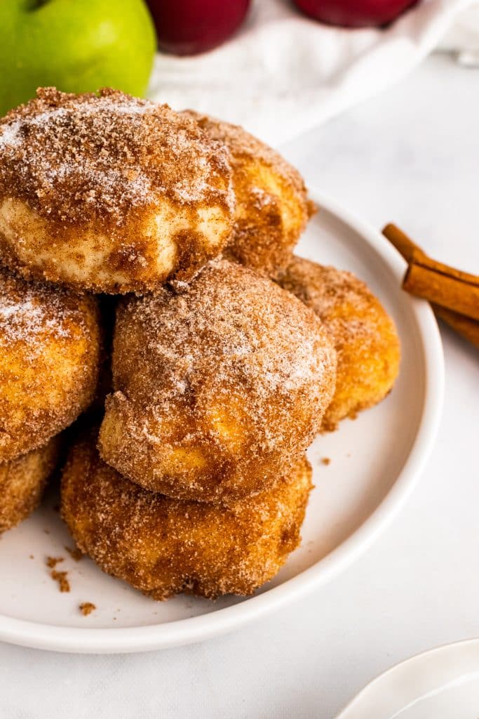 cinnamon sugar covered caramel apple pie bombs piled on a white plate