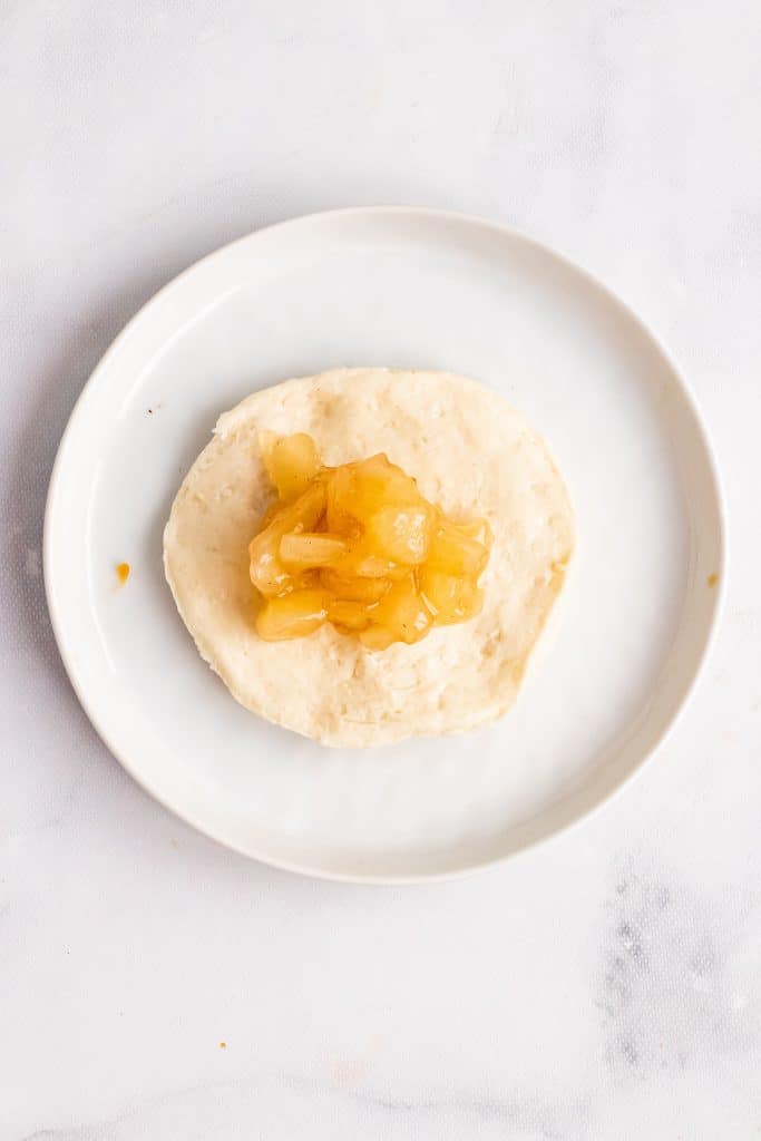a flattened refrigerated biscuit topped with apple pie filling