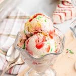 three scoops of copycat little debbie christmas tree cake ice cream in a glass ice cream bowl