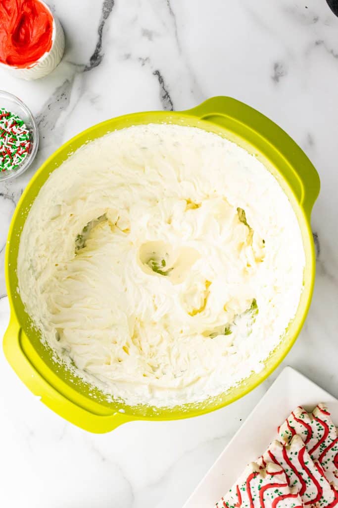 whipped heavy cream in a large green mixing bowl