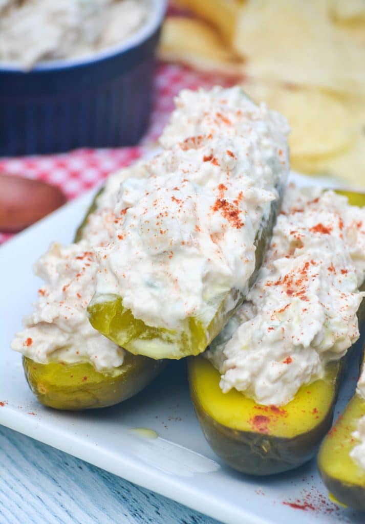 three stuffed pickle boats stacked on a white serving platter