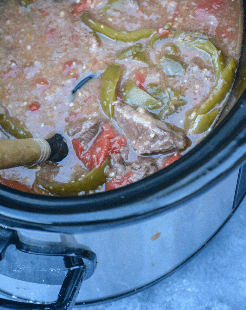 a slow cooker filled with crockpot pepper steak