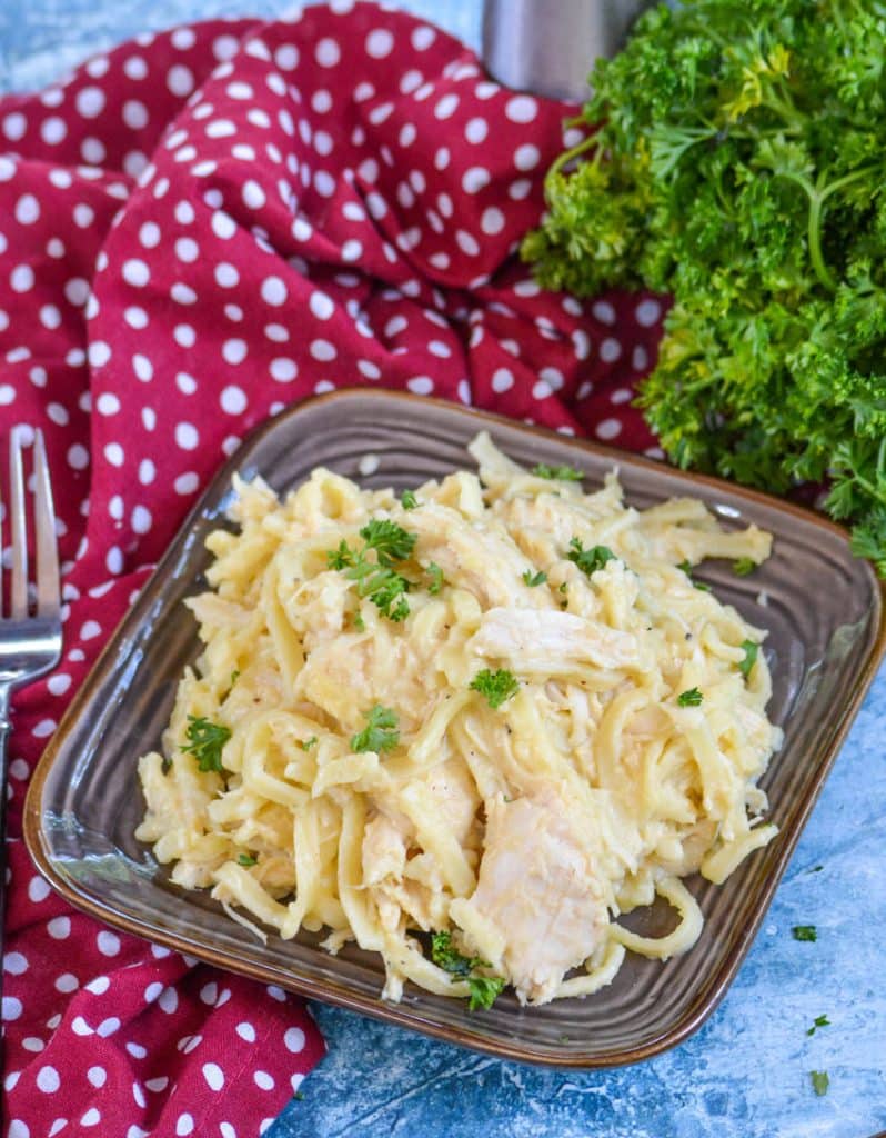 slow cooker cheesy chicken & noodles in the black bowl of a crockpot