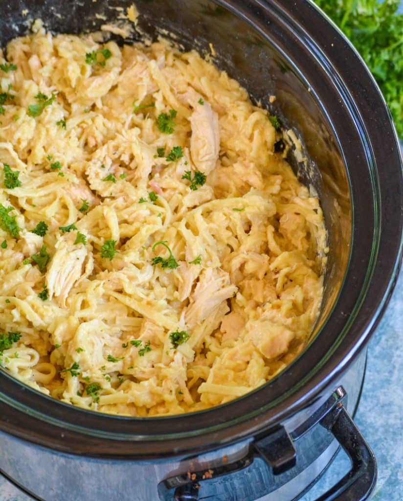 cheesy chicken & noodles in the black bowl of a crockpot