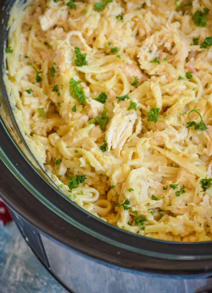 cheesy chicken & noodles in the black bowl of a crockpot