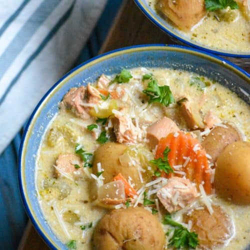 crockpot chicken stew in a blue bowl topped with shredded Parmesan cheese