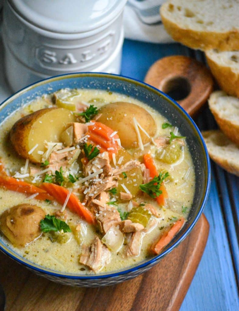 crockpot chicken stew in a blue bowl topped with shredded Parmesan cheese