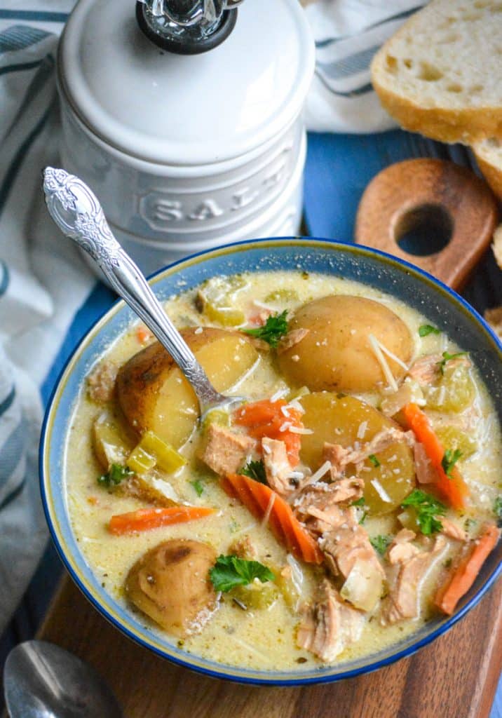 crockpot chicken stew in a blue bowl with a silver spoon resting on the edge