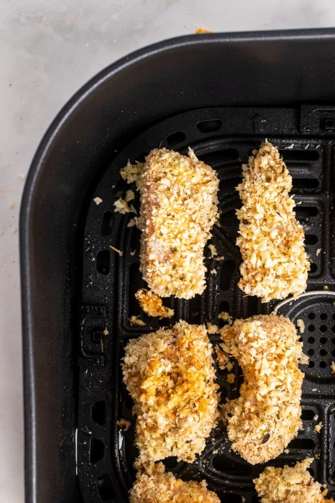 homemade panko breaded fish sticks in an air fryer basket