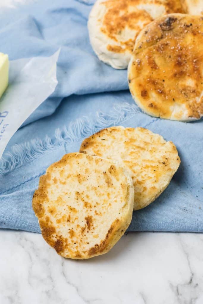 homemade english muffins on a blue cloth napkin