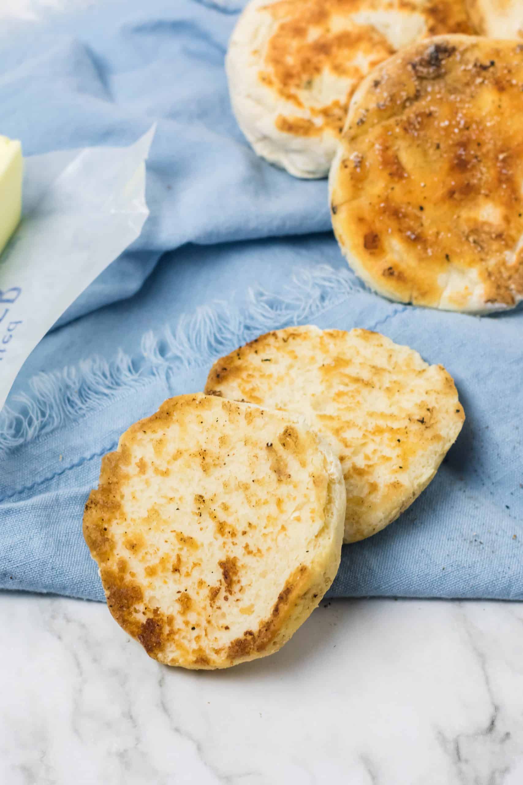 homemade english muffins on a blue cloth napkin