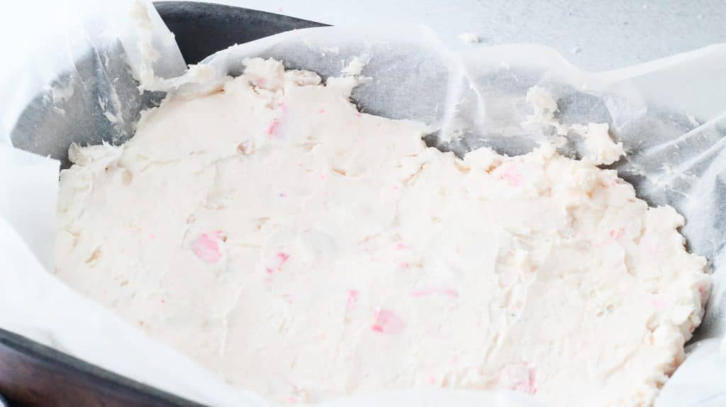 circus cookie fudge spread out in a parchment lined baking dish