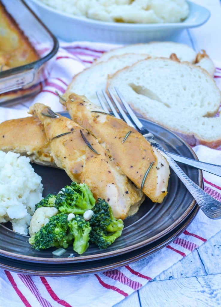 marry me dijon rosemary chicken served on a brown plate next to steamed broccoli and mashed potatoes with a silver fork on the side