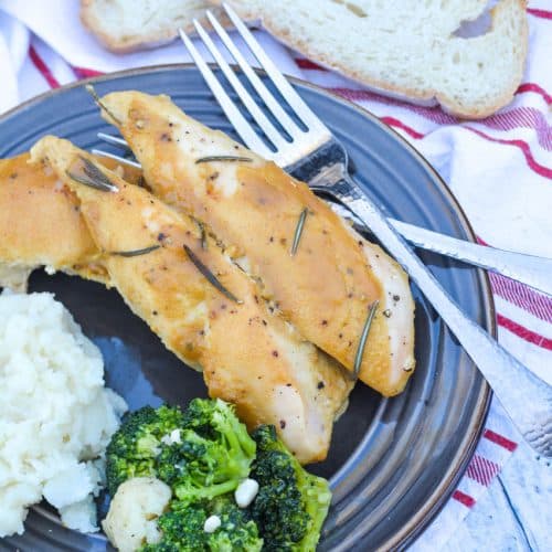 marry me dijon rosemary chicken served on a brown plate next to steamed broccoli and mashed potatoes with a silver fork on the side