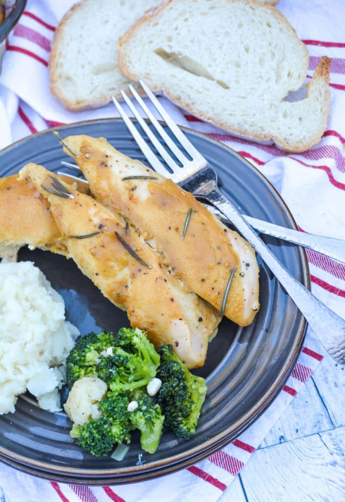 marry me dijon rosemary chicken served on a brown plate next to steamed broccoli and mashed potatoes with a silver fork on the side