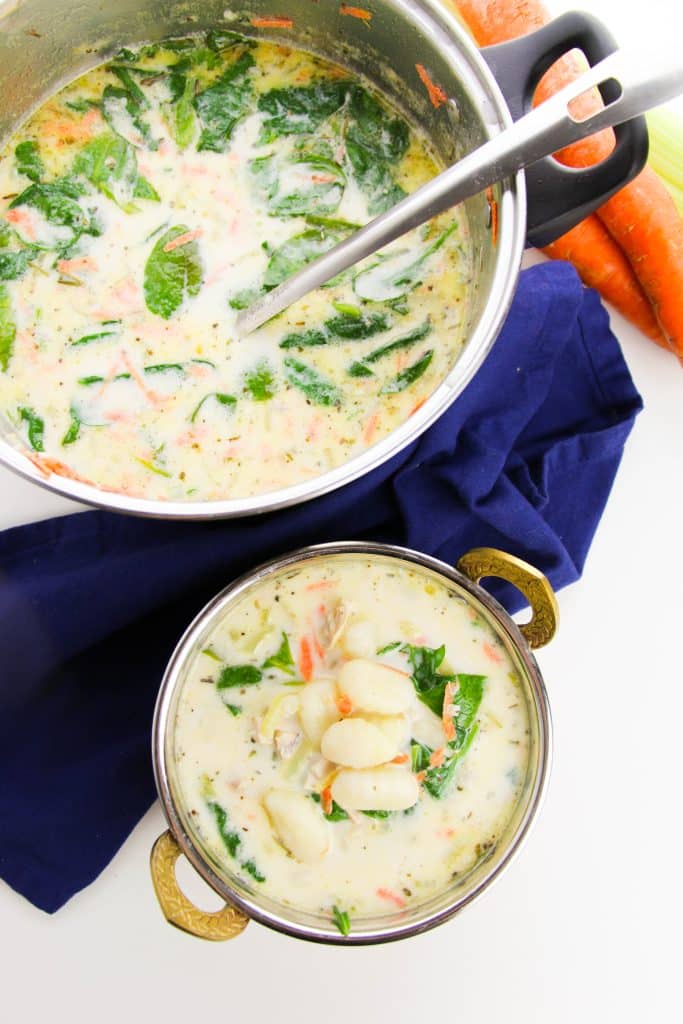 copycat olive garden chicken & gnocchi soup in a small bowl next to a silver pot