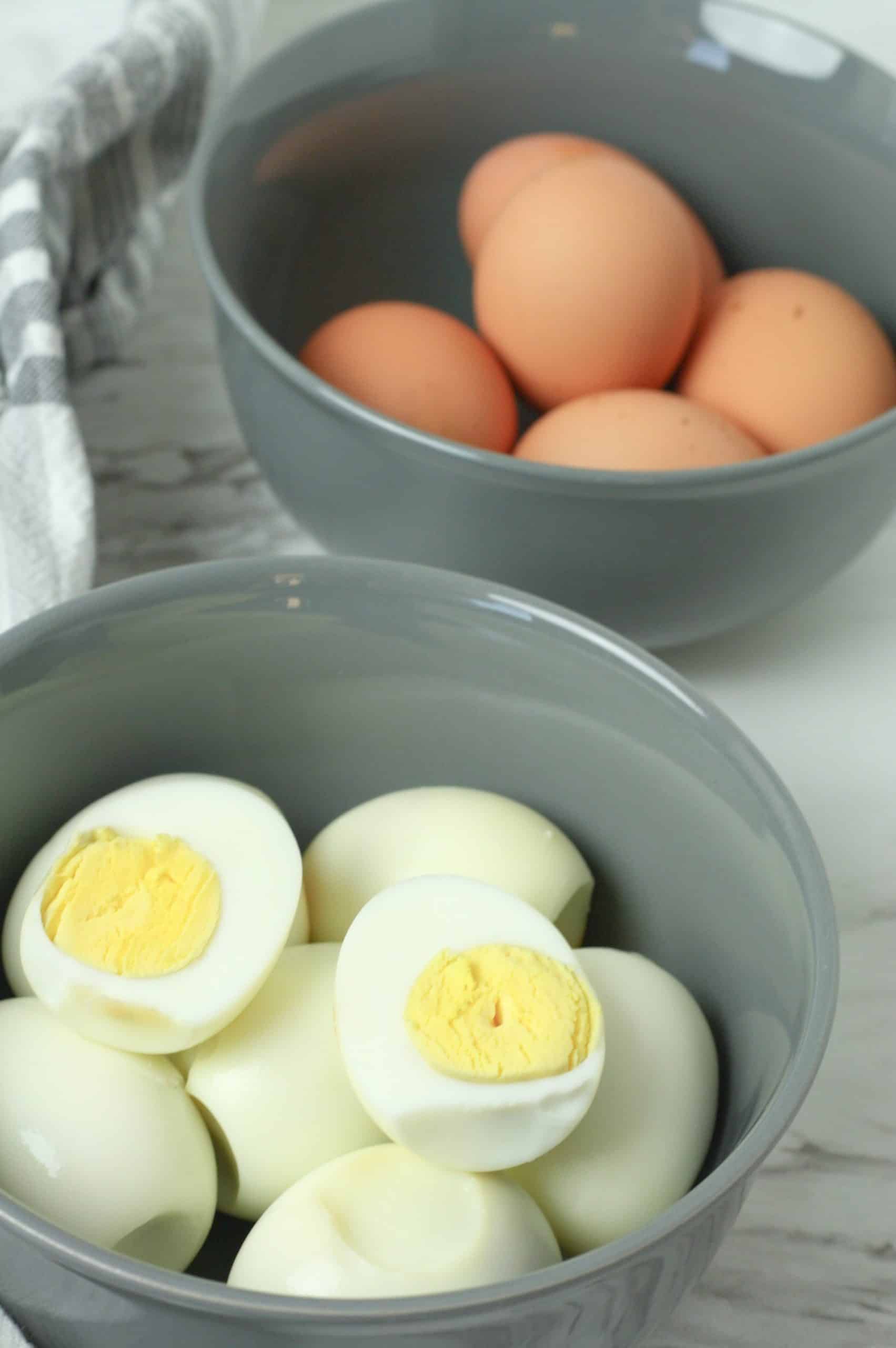 Oven Baked Hard Boiled Eggs oven baked hard boiled eggs shown peeled & cut in half and piled in a gray bowl
