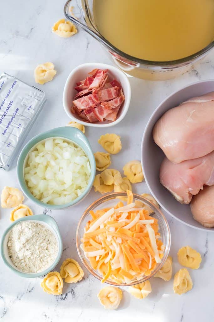 overhead image showing all of the measured ingredients needed to make slow cooker crack chicken tortellini soup