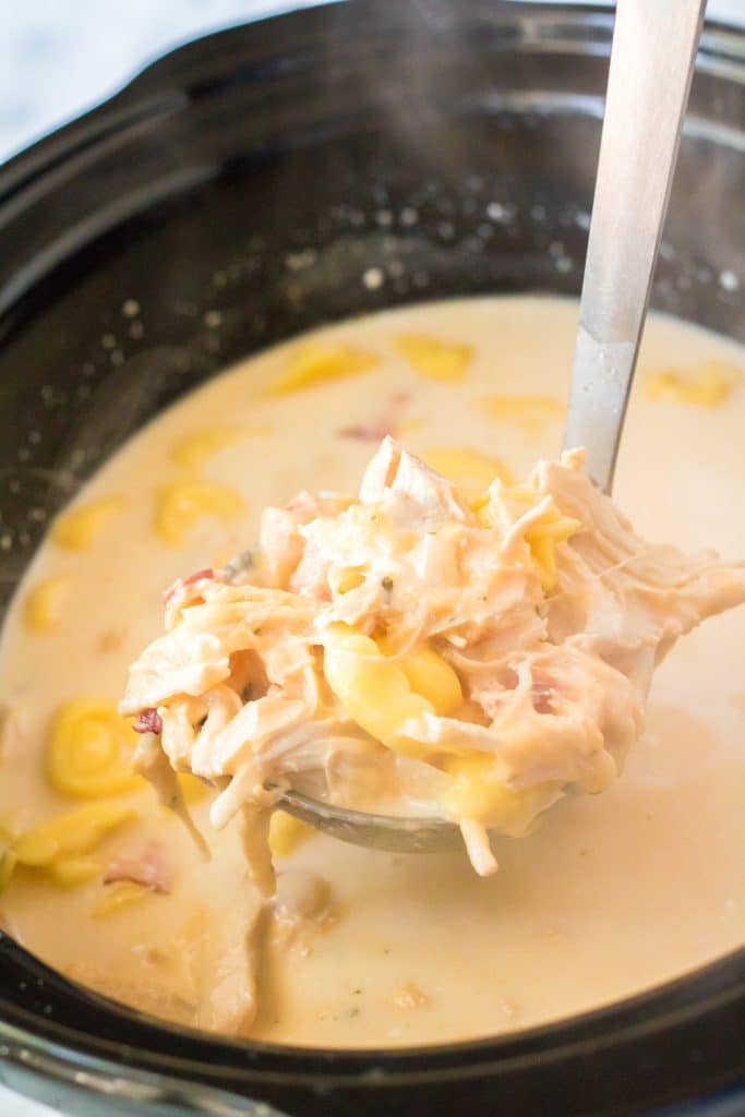 a ladle holding up a scoop of slow cooker crack chicken soup
