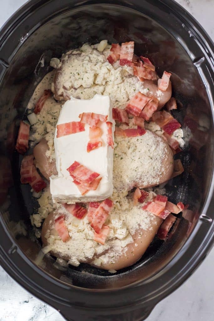 crack chicken ingredients layered in a black crockpot