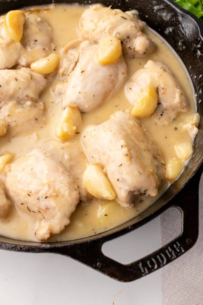 pan seared chicken thighs in garlic gravy in a black cast iron skillet