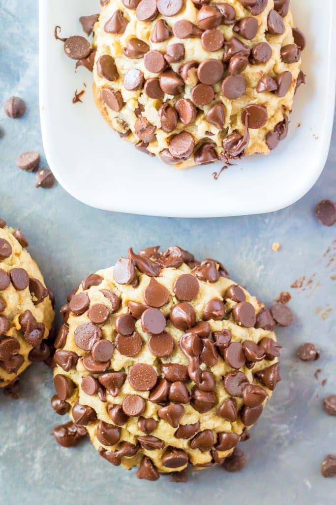 giant chocolate chip cookie in front of a white platter of cookies