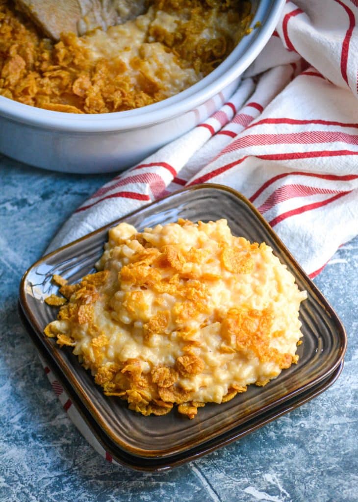 Instant pot funeral potatoes on small brown plates sitting in front of a pressure cooker