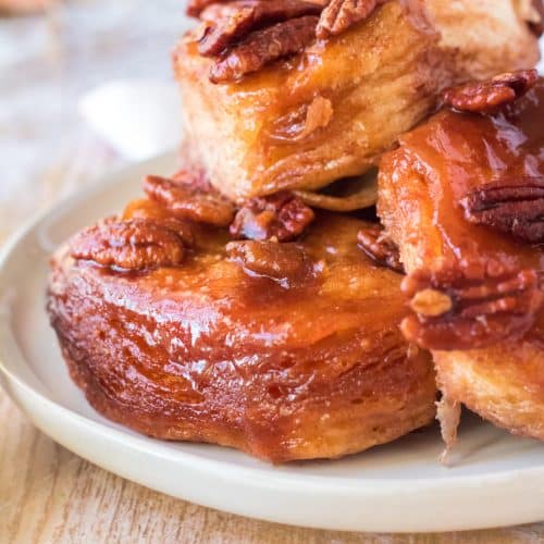 slow cooker sticky buns with pecans piled high on a white plate