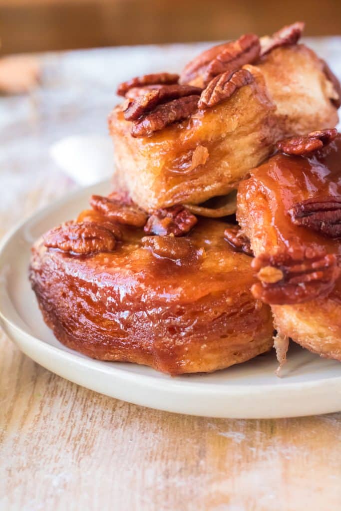 slow cooker sticky buns with pecans piled high on a white plate