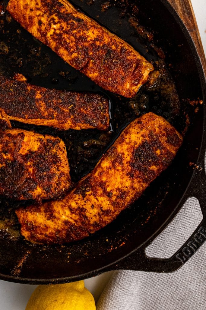 blackened salmon filets in a cast iron skillet
