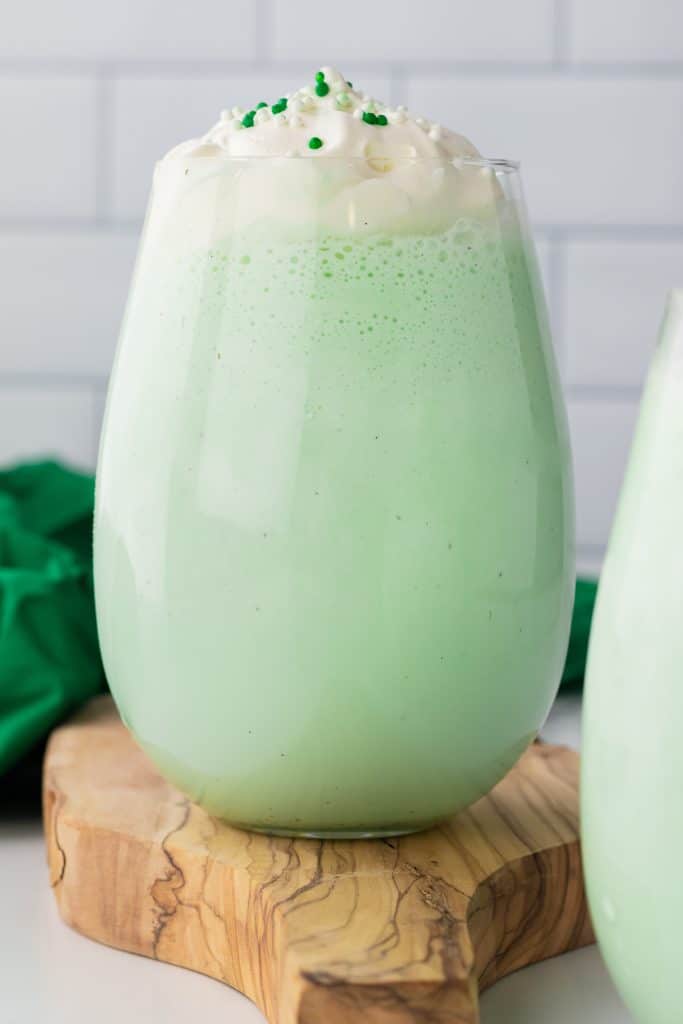 copycat shamrock shake in a glass cup topped with whipped cream and green sprinkles