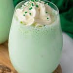 copycat shamrock shake in a glass cup topped with whipped cream and green sprinkles