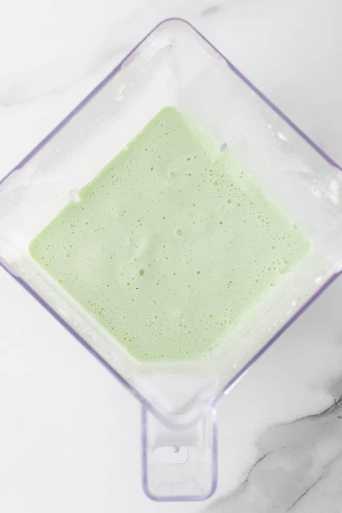 blended minty green milkshake in a blender