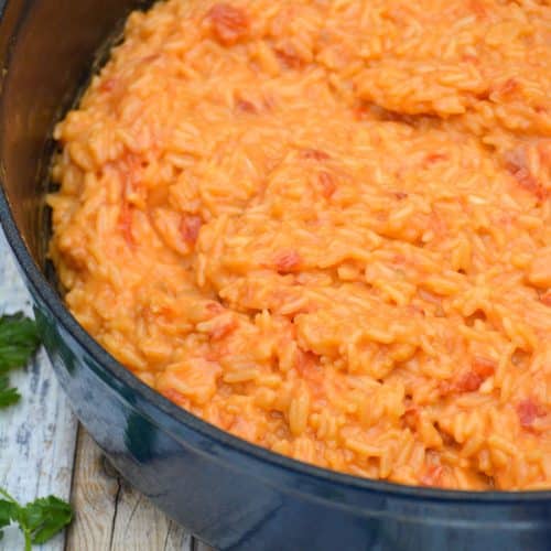 cheesy queso rice in a blue enameled cast iron dutch oven