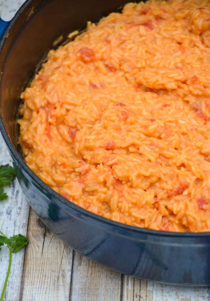 cheesy queso rice in a blue enameled cast iron dutch oven