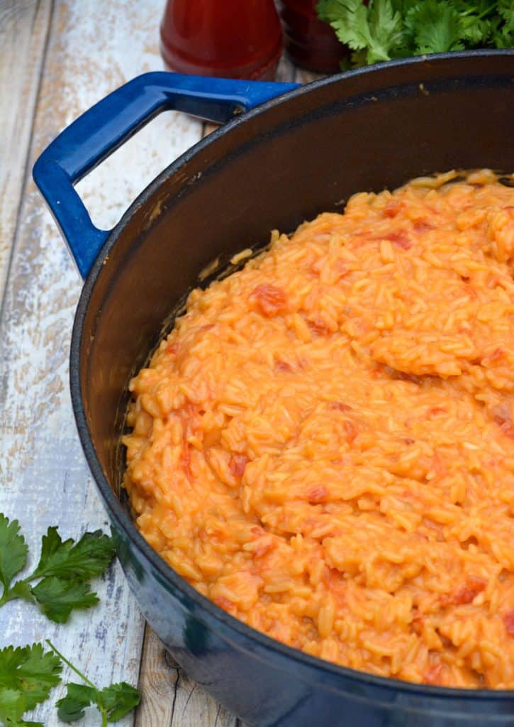 cheesy queso rice in a blue enameled cast iron dutch oven
