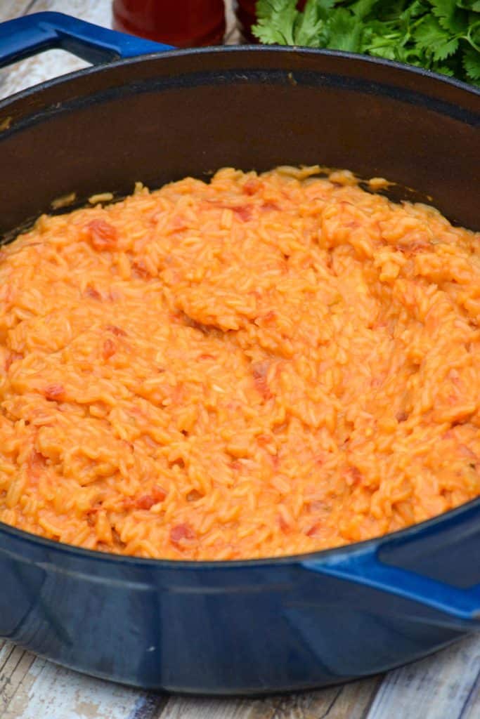 cheesy queso rice in a blue enameled cast iron dutch oven