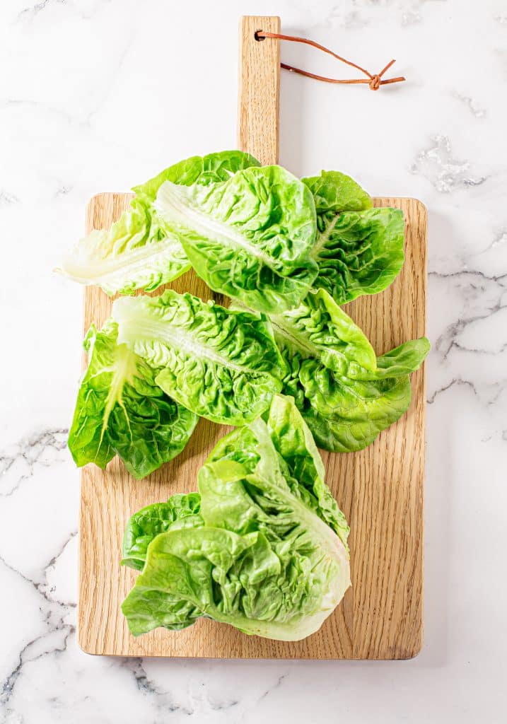 prepared lettuce green lettuce leaves on a small wooden cutting board