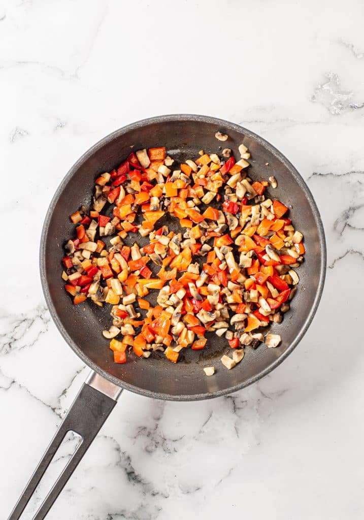 sauteed mushrooms and peppers in a small black skillet
