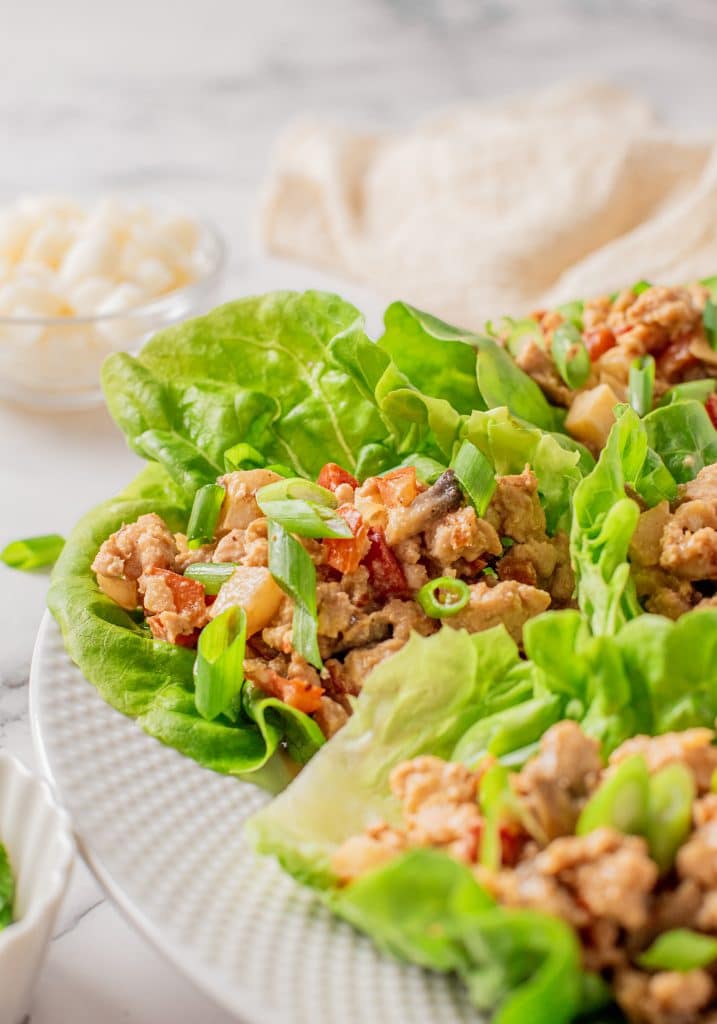 chicken lettuce wraps on a white plate