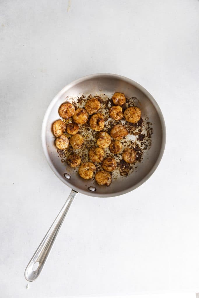 cooked seasoned shrimp in a silver skillet
