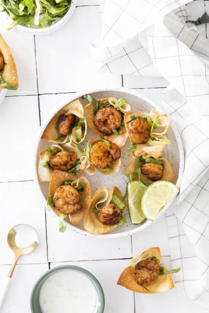 a white plate full of shrimp taco bites in wonton cups